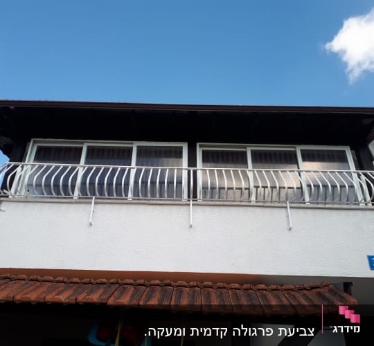 מעקה מתכת לבן על מרפסת בית